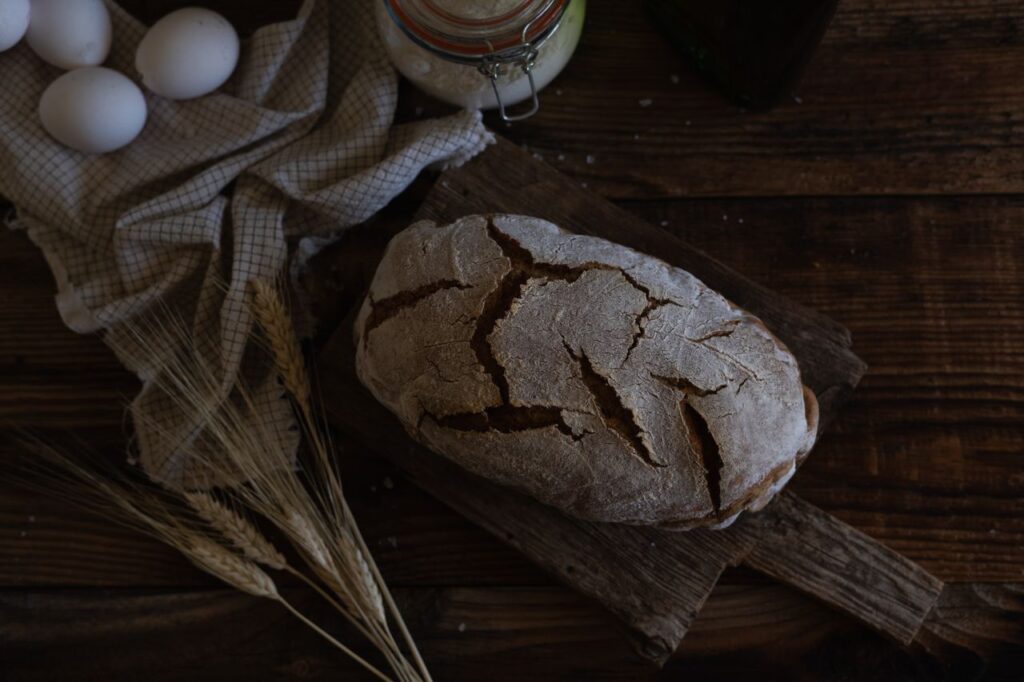 pexels-photo-30895291-30895291 Artistic shot of homemade rustic bread with eggs and wheat on wooden table.